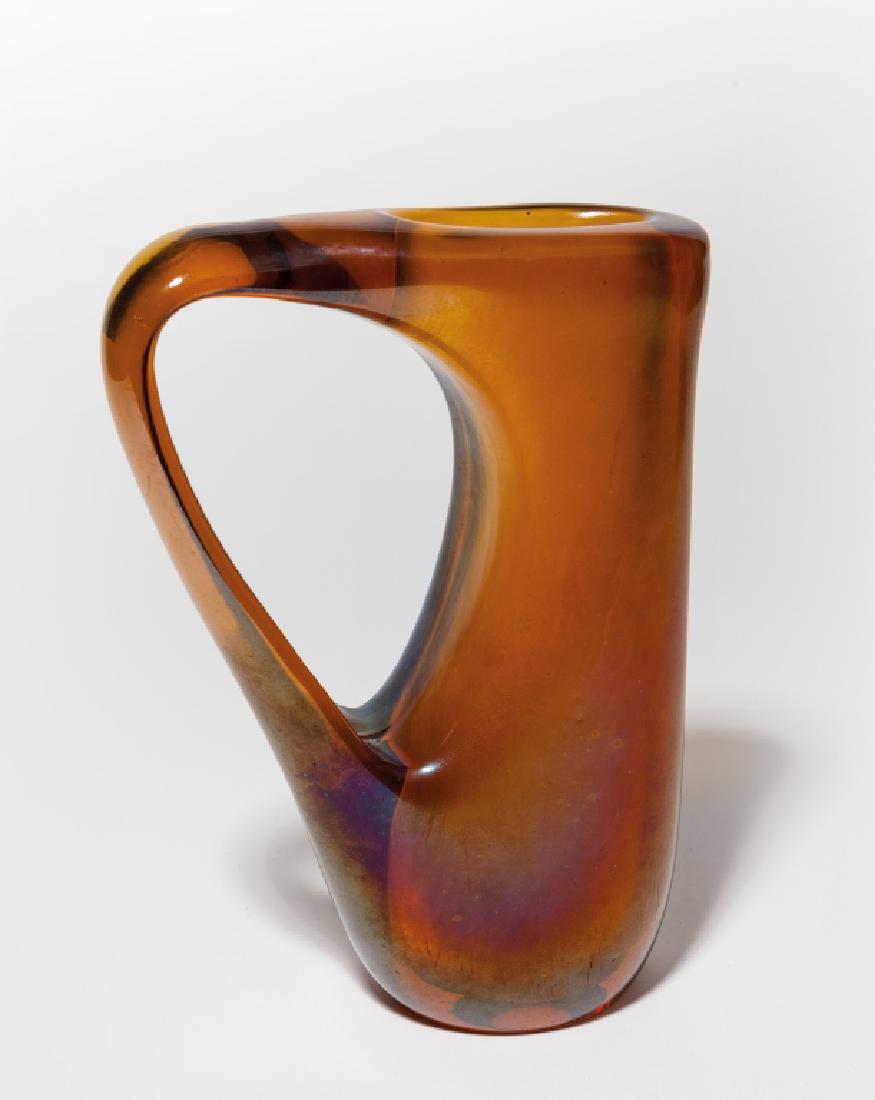 GIORGIO FERRO, A.VE.M. Un vaso "Ansa volante",: GIORGIO FERRO, A.VE.M. Un vaso "Ansa volante", 1955. Vetro ambra iridato. Un piccolo difetto. Altezza cm 24.