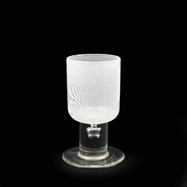 TAPIO WIRKKALA VENINI Un bicchiere in: TAPIO WIRKKALA VENINI Un bicchiere in filigrana lattimo della serie 'Bicchieri di Tapio', circa 1966. Marca incisa 'venini italia tw'. Altezza cm 14. Letteratura: Franco Deboni 'I vetri' Venini, catal