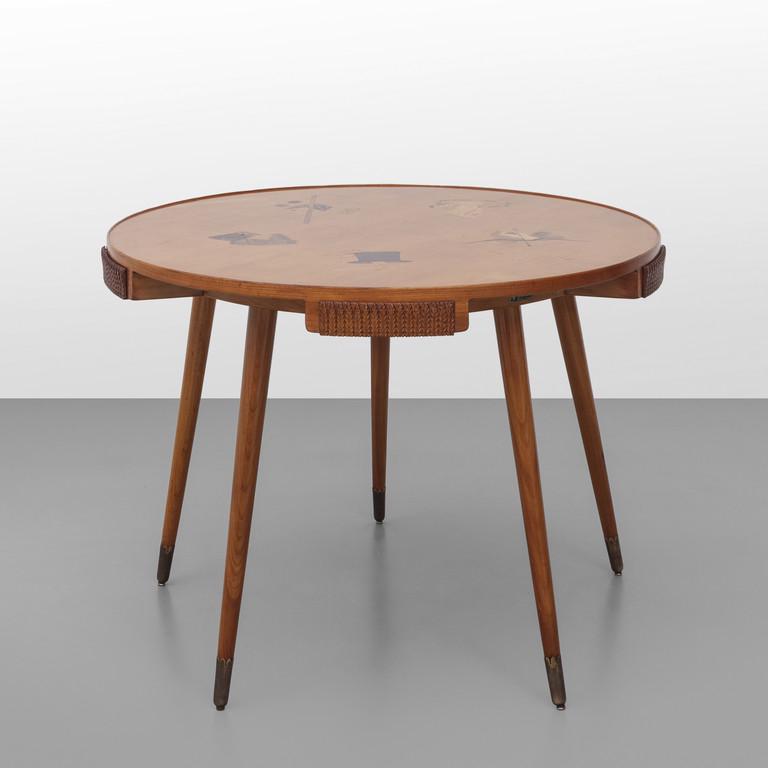 OSVALDO BORSANI Un tavolo da gioco per: OSVALDO BORSANI Un tavolo da gioco per ARREDAMENTI BORSANI, Varedo, anni '50. Legno di ciliegio, legno impiallacciato in ciliegio e tarsie di legni vari, puntali di ottone. Targhetta metallica'Arredam
