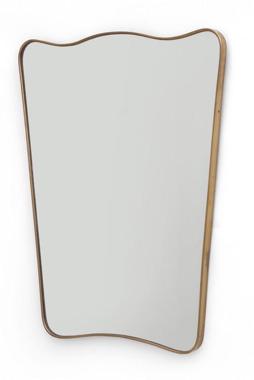 UNO SPECCHIO DA PARETE, anni '50. Ottone,: UNO SPECCHIO DA PARETE, anni '50. Ottone, cristallo argentato. Cm 89 x 69.