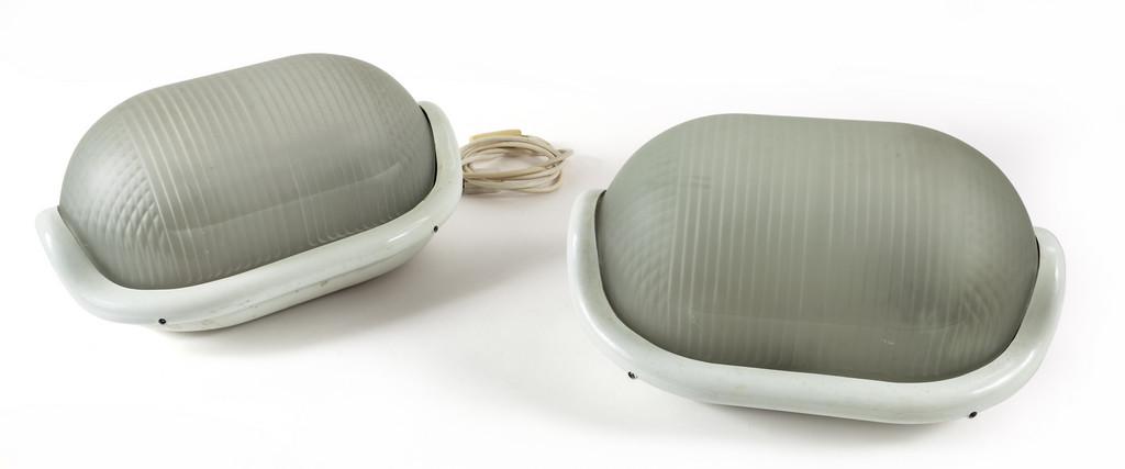 ACHILLE CASTIGLIONI Due lampade da parete: ACHILLE CASTIGLIONI Due lampade da parete 'Noce' per FLOS, 1972. Alluminio pressofuso verniciato, vetro stampato, due portalampada orientabili. Cm 18,5 (h) x 36 x 25. Letteratura: Domus 514 (settembre