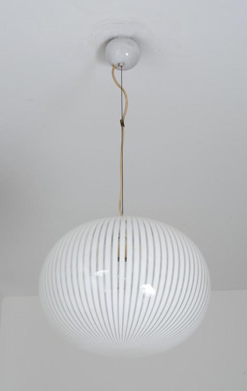 UNA LAMPADA A SOSPENSIONE, anni '70. Acciaio: UNA LAMPADA A SOSPENSIONE, anni '70. Acciaio verniciato, vetro cristallo soffiato con fasce di vetro bianco. Altezza del diffusore cm , diametro cm .