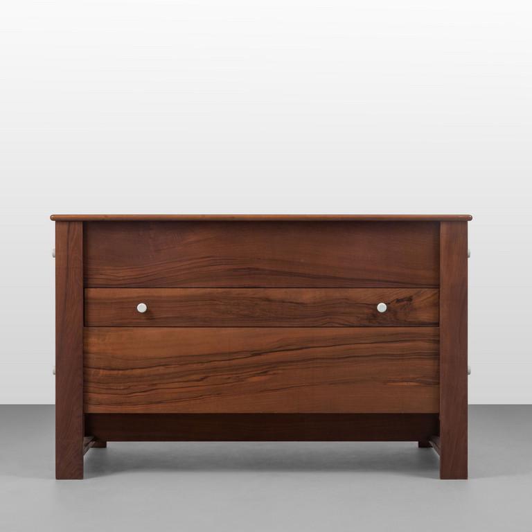 ANTONIO ROSSIN, BERNINI, anni '70 Un: ANTONIO ROSSIN, BERNINI, anni '70 Un cassettone modello '353'. Legno impiallacciato in noce, maniglie di porcellana. un cassetto frontale e quattro cassetti laterali. Etichetta della Manifattura in un