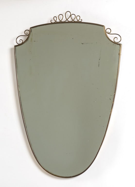 UNO SPECCHIO DA PARETE, anni '50. Ottone,: UNO SPECCHIO DA PARETE, anni '50. Ottone, cristallo argentato. Cm 87 x 58.