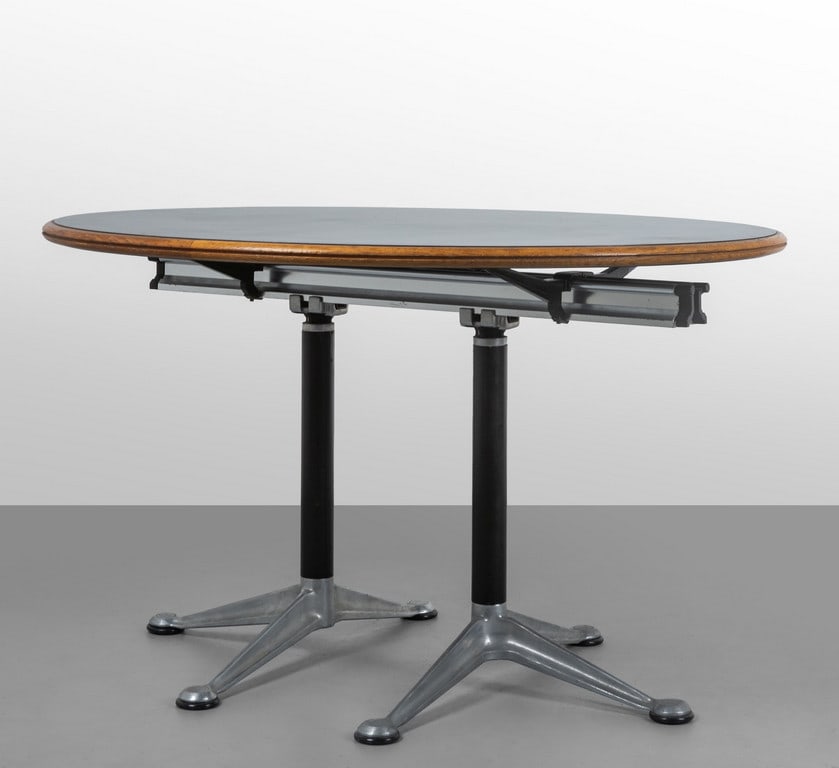 BRUCE BURDICK, HERMAN MILLER, anni '80. Un: BRUCE BURDICK, HERMAN MILLER, anni '80. Un tavolo del 'Sistema Burdick Group'. Alluminio pressofuso, laminato, rovere. Altezza cm 74, diametro cm 120.