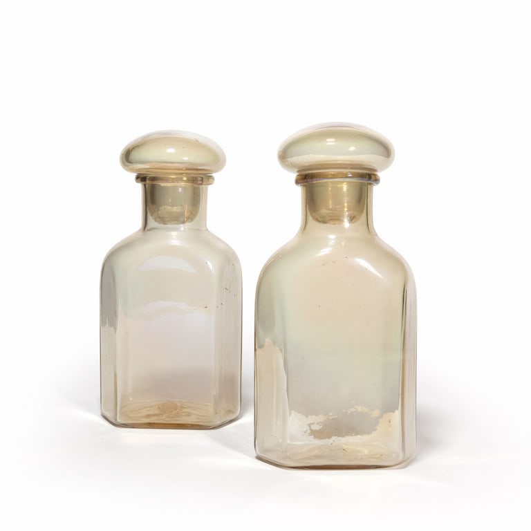 BAROVIER & TOSO, anni '50. Due bottiglie a: BAROVIER & TOSO, anni '50. Due bottiglie a sezione esagonale in cristallo ambrato iridato. Etichette originali. Altezza cm 27,5.