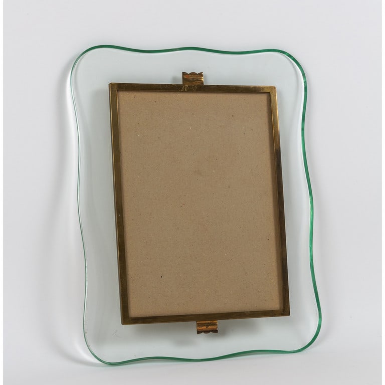 UN PORTARITRATTI DA PARETE, anni '50.: UN PORTARITRATTI DA PARETE, anni '50. Cristallo sagomato e molato, ottone. Cm 35 x 29.