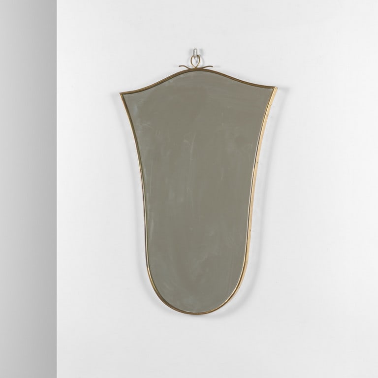 UNO SPECCHIO DA PARETE, anni '50. Ottone,: UNO SPECCHIO DA PARETE, anni '50. Ottone, cristallo argentato. Cm 75 (h) x 48.