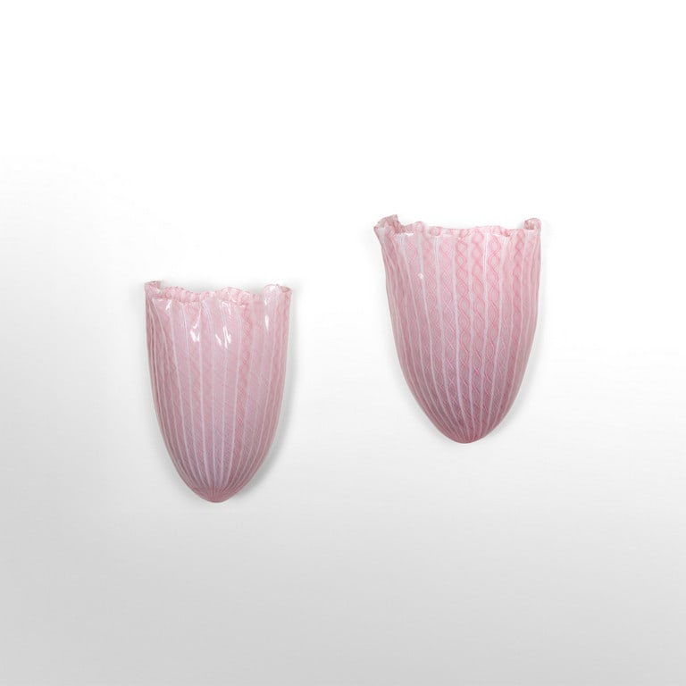 VENINI (Editore), anni 50. Due lampade da: VENINI (Editore), anni 50. Due lampade da parete. Vetro a canne di zanfirico rosa. Cm 25 (h) x 20 (l) x 11 (p). A pair of wall lamps. Pink zanfirico glass rods. Inches 9.8 (h) x 7.9 (w) x 4.3 (d).