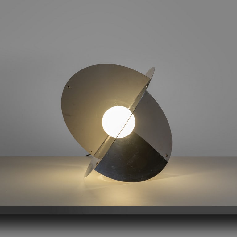 RINALDO CUTINI, NEW LAMP, anni 70. Una: RINALDO CUTINI, NEW LAMP, anni 70. Una lampada da tavolo 'Luna'. Acciaio inox cromato. Cm 40 (diam.). A table lamp 'Luna'. Chrome-plated steel. Inches 19.7 (diam.). Letteratura: Domus 502 (settembre 1