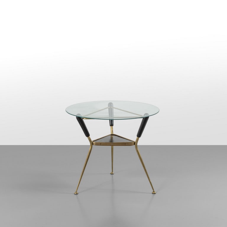 UN TAVOLINO, anni '50. Legno ebanizzato,: UN TAVOLINO, anni '50. Legno ebanizzato, ottone, cristallo (piccolissime mancanze sul bordo). Cm 50 (h) x 60 (diam.).