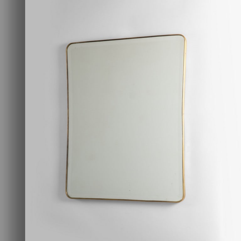 UNO GRANDE SPECCHIO DA PARETE, anni '50.: UNO GRANDE SPECCHIO DA PARETE, anni '50. Ottone, cristallo molato argentato. Piccola mancanza nella parte alta a sinistra, in prossimità' della molatura. Cm 90 (h) x 72.