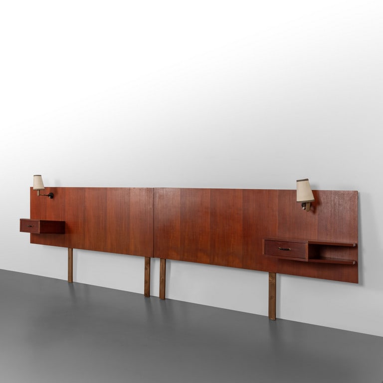 UNA TESTIERA LETTO, anni '60. Legno di teak,: UNA TESTIERA LETTO, anni '60. Legno di teak, testiera attrezzata dotata di comodini e illuminazione. Cm 90 (h) x 310 (l) x 40 (p).