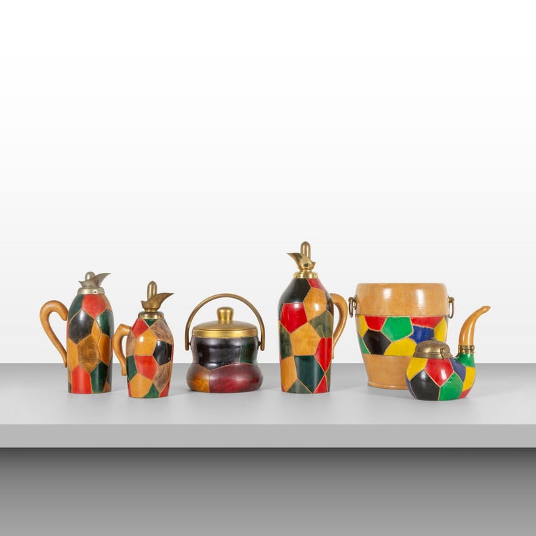 ALDO TURA, MACABO, anni '60. Un set composto: ALDO TURA, MACABO, anni '60. Un set composto da: un secchiello porta bottiglie, un secchiello portaghiaccio, tre thermos, un porta tabacco. Legno con intagli geometrici dipinti all'anilina, ottone. Ma