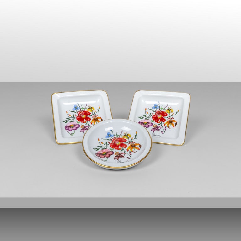 GUCCI (Editore), anni '70. Tre posacenere: GUCCI (Editore), anni '70. Tre posacenere realizzati da Richard Ginori. Porcellana con decoro 'Gucci Flora'. Marcati 'Richard Ginori Manifattura di Doccia Italy for Gucci' Cm 14 x14 13 (diam.)