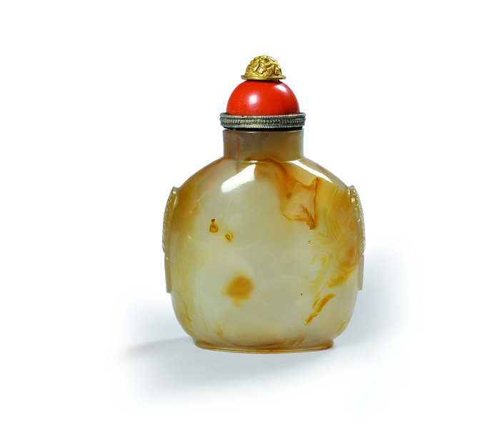 Grande Snuff-bottle in agata scolpita tappo in: Grande Snuff-bottle in agata scolpita tappo in corallo sormontato da decori in bronzo dorato. Cina inizi sec. XIX h cm 11,5