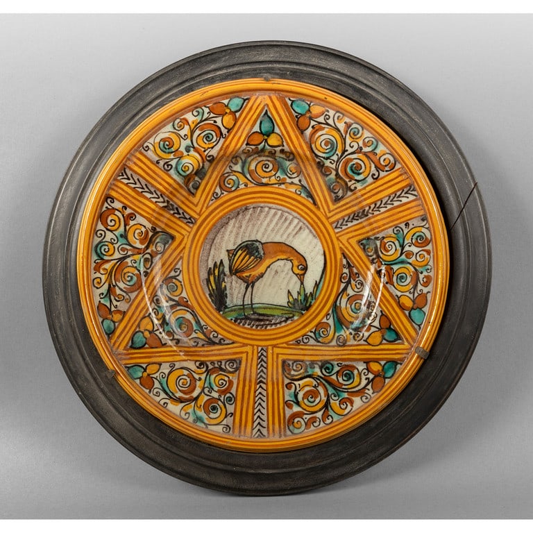 Piatto in maiolica policroma decorato con disegni: Piatto in maiolica policroma decorato con disegni geometrici e floreali con al centro un fenicottero, sul retro scritta Map.Pesaro, cornice in legno ebanizzato diam.cm.25, cm.tot.32