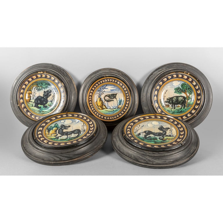 Cinque piatti in maiolica decorati con animali: Cinque piatti in maiolica decorati con animali fantastici con cornice in legno ebanizzato, nel retro sigla Map.Pesaro diam.cm.17, cm.tot.27
