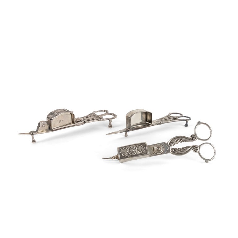 Lotto composto da 3 forbici spegnimoccolo in: Lotto composto da 3 forbici spegnimoccolo in argento, probabilmente di produzione inglese, in buone condizioni di conservazione. Dimensioni 18 x 5 cm cad. Peso 332 g.