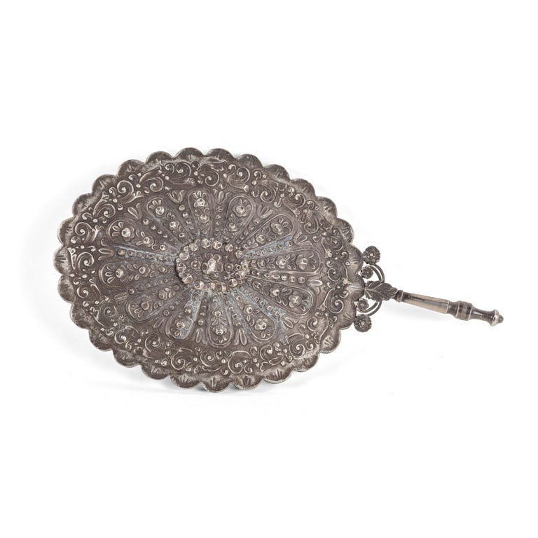 Specchio da mano per toeletta, in argento: Specchio da mano per toeletta, in argento sbalzato e cesellato con motivi floreali e volute fogliacee. Secolo XIX (Ottomano?) con rotture e difetti. Dimensioni 34 x 18 cm. Peso lordo 385,72 g.