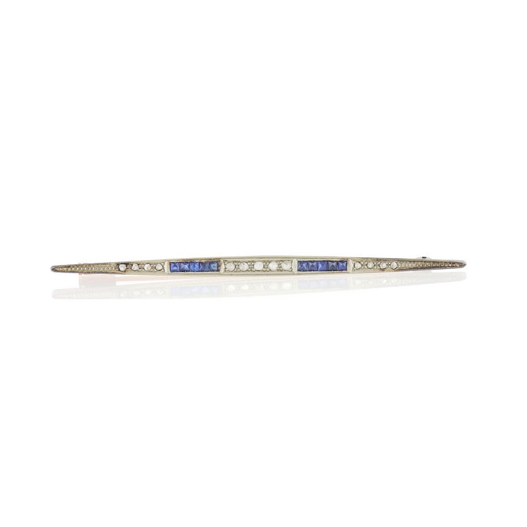 Classica spilla a barretta di epoca '900,: Classica spilla a barretta di epoca '900, realizzata in oro giallo e platino, piccoli zaffiri e diamanti a decoro. Lunghezza 7 cm. Peso 2,97 g.