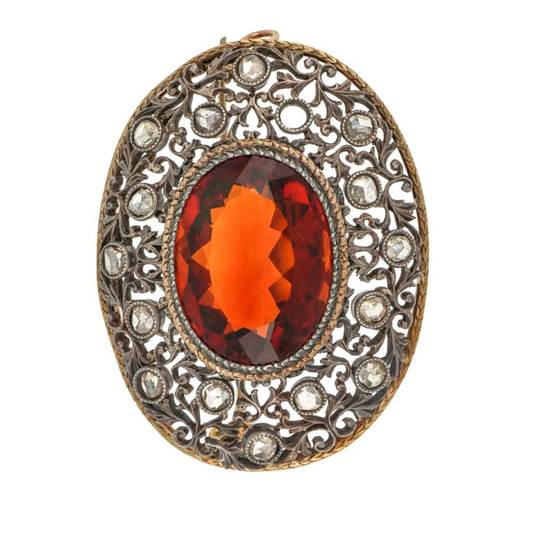 Spilla d'epoca trasformabile a ciondolo in oro e: Spilla d'epoca trasformabile a ciondolo in oro e argento con grande quarzo citrino arancione e diamanti taglio a rosa (uno mancante), bel lavoro di traforo. Dimensione 55 x 35 mm. Peso 16,91 g.
