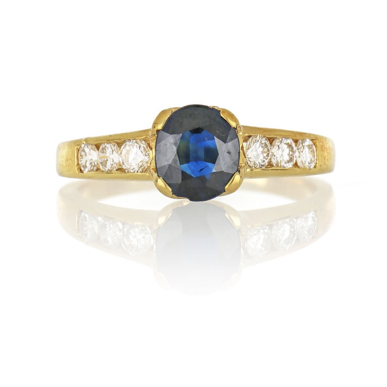 Anello in oro giallo, il gambo sottile sostiene: Anello in oro giallo, il gambo sottile sostiene uno zaffiro taglio ovale di ct. 1,00 ca. ed è incassato con piccoli diamanti taglio brillante per ct. 0,30 ca. Misura n. 13. Peso 4,39 g.