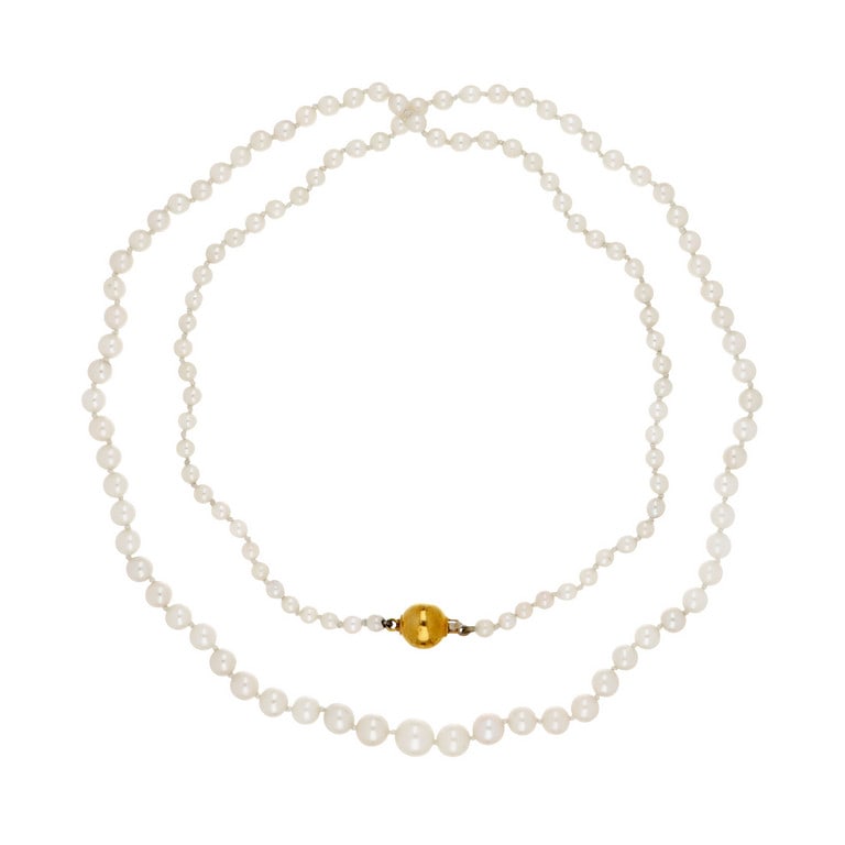 Lunga collana di perle scalari giapponesi: Lunga collana di perle scalari giapponesi coltivate, da 4 a 8,2 mm di diametro, al centro chiusura a sfera lucida in oro giallo. Lunghezza 80 cm. Peso 26,8 g.