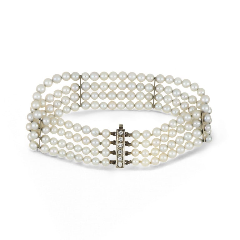 Braccialetto in oro bianco realizzato con 4 fili: Braccialetto in oro bianco realizzato con 4 fili di perle giapponesi coltivate di 4 mm, intercalate da barrette di giunzione e decorato con piccoli diamanti taglio brillante sulla chiusura a baionetta