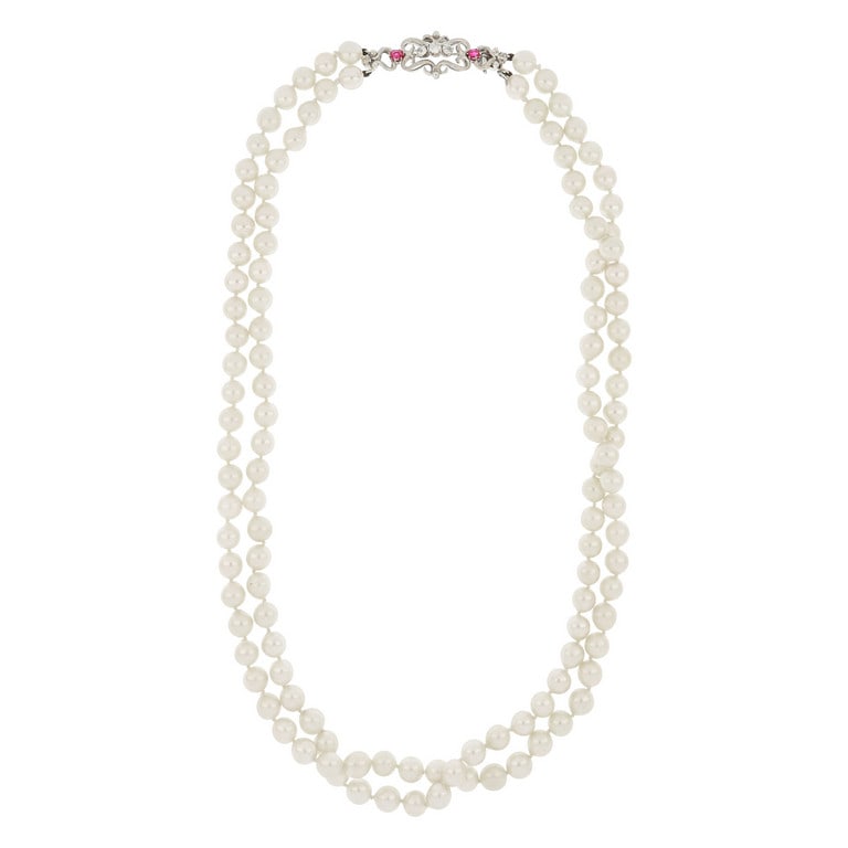 Collana di perle giapponesi coltivate, 7,5/8 mm: Collana di perle giapponesi coltivate, 7,5/8 mm di diametro, al centro una elegante chiusura in oro bianco a volute, con piccoli rubini e diamanti taglio antico. Lunghezza 58 cm. Peso 91,02 g.