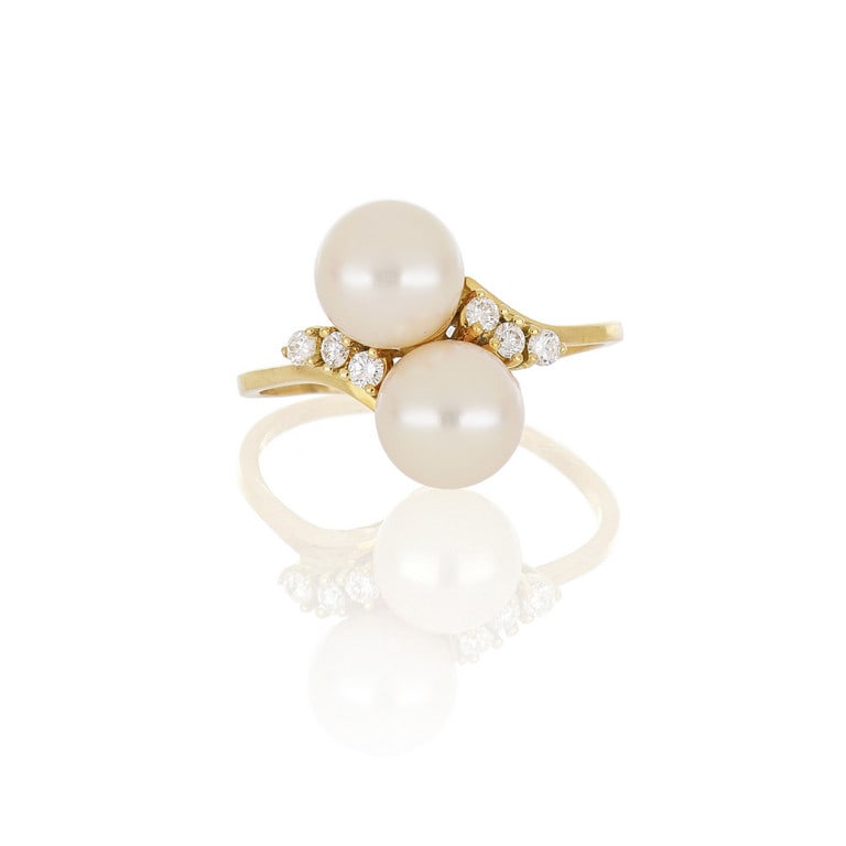 Anello in oro giallo, due perle giapponesi: Anello in oro giallo, due perle giapponesi coltivate che si abbracciano sormontano un esile gambo. Misura n. 16. Peso 4,80 g.