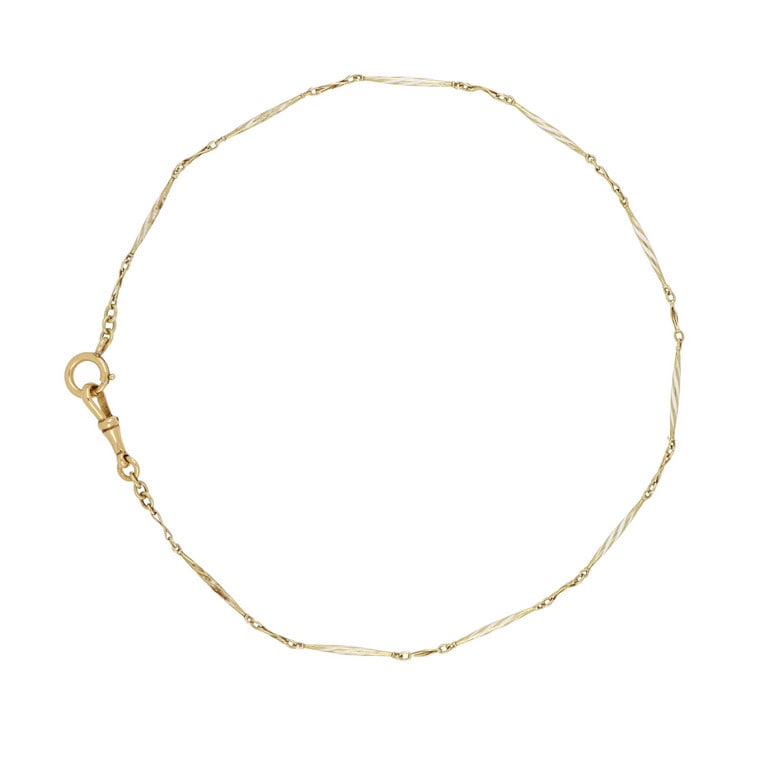 Finissima catenina da orologio in oro giallo e: Finissima catenina da orologio in oro giallo e smalti bianchi. Lunghezza 35 cm. Peso 6,38 g.