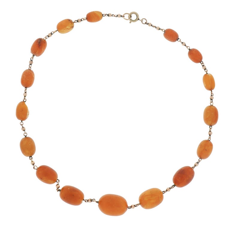 Collana di ambra antica a bussolotti, intercalati: Collana di ambra antica a bussolotti, intercalati da una catena a rol'o' con sferule in oro rosso basso titolo. Lunghezza 42 cm. Peso 21,59 g.
