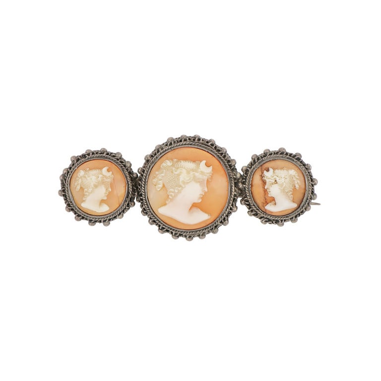 Spilla in argento con 3 camei su conchiglia,: Spilla in argento con 3 camei su conchiglia, finemente intagliati con volti femminili, due purtroppo danneggiati. Dimensioni 5,5 x 2,2 cm. Peso 12,48 g.