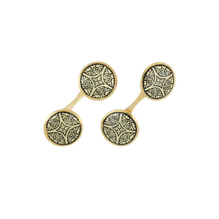 Gemelli in oro giallo di forma rotonda, a decoro: Gemelli in oro giallo di forma rotonda, a decoro un disegno arabescato e smaltato di nero. Dimensioni 13 mm di diametro. Peso 6,60 g.