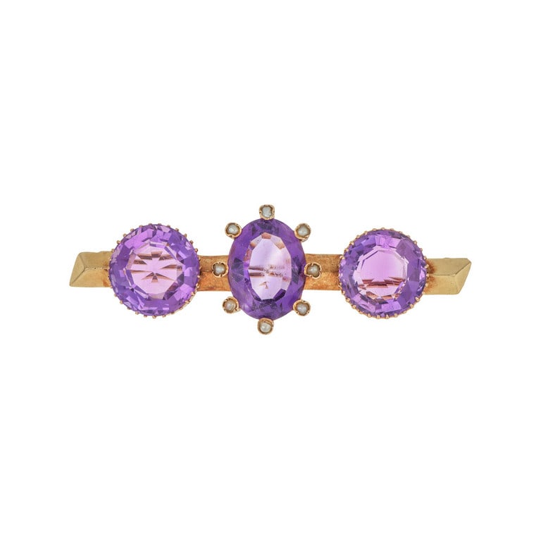 Spilla in oro rosso, con tre grandi quarzi: Spilla in oro rosso, con tre grandi quarzi ametista due di forma rotonda ed il centrale ovale incassato da punte con piccoli diamantini sulla sommità. Lunghezza 65 mm. Peso 13,33 g.