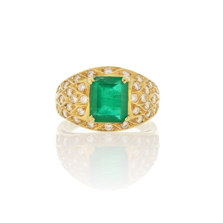 Anello in oro giallo a musone, uno smeraldo: Anello in oro giallo a musone, uno smeraldo taglio rettangolare di ct. 2,00 ca. è decorato con piccoli diamanti taglio brillante con curiosa incassatura a mandorla, ct. 0,50 ca. Misura n. 10. Pes