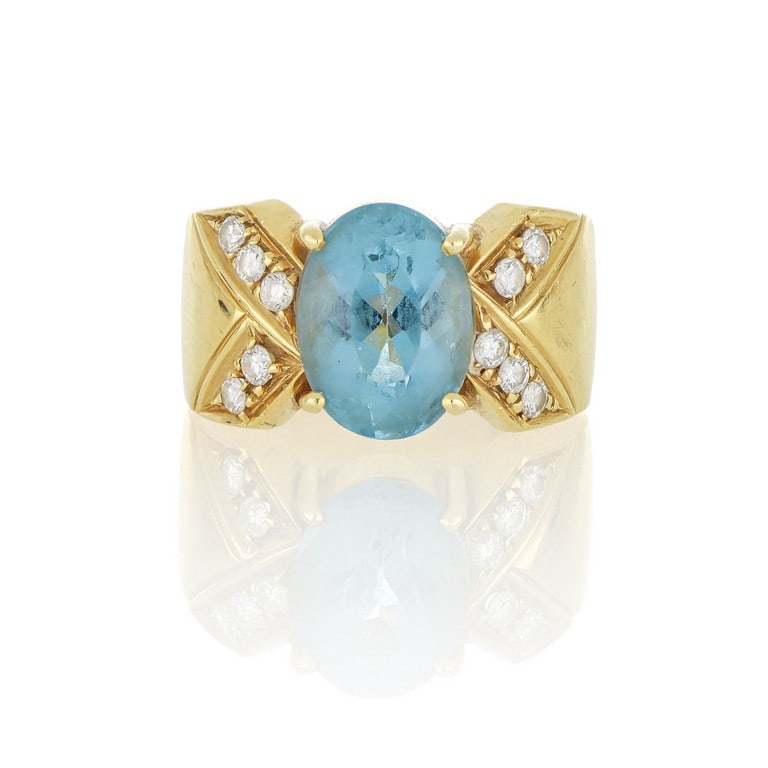 Anello a fascia con una intensa acquamarina di: Anello a fascia con una intensa acquamarina di colore azzurro, taglio ovale di ct. 2,50 ca., realizzato in oro giallo lucido, con piccoli diamanti taglio brillante a decoro. Misura n. 8. Peso 9,64 g.