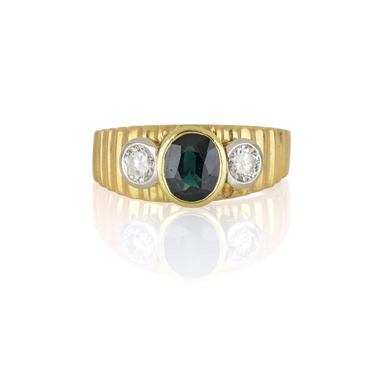 Anello in oro giallo a fascetta, la lavorazione a: Anello in oro giallo a fascetta, la lavorazione a cannetè è sormontata al centro da uno zaffiro taglio ovale e due diamanti taglio brillante ai lati, ct. 0,20 ca. Misura n. 12. Peso 4,65 g.