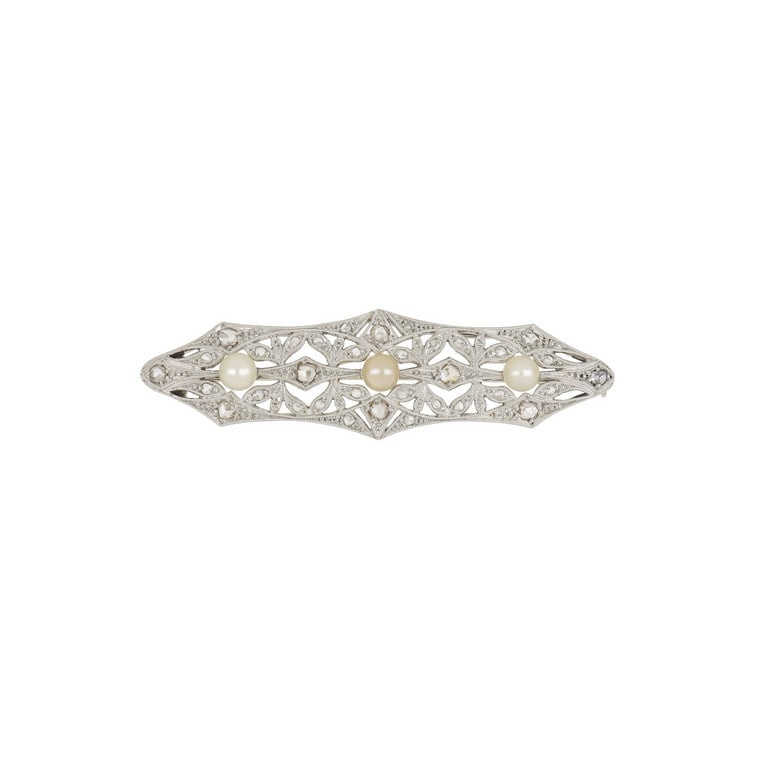 Spilla a barretta in platino, la forma ovale: Spilla a barretta in platino, la forma ovale allungata è decorata con diamanti taglio rosa, 3 perline, incisioni e trafori. Dimensioni 5,5 x 1,5 cm Peso 7,86 g.