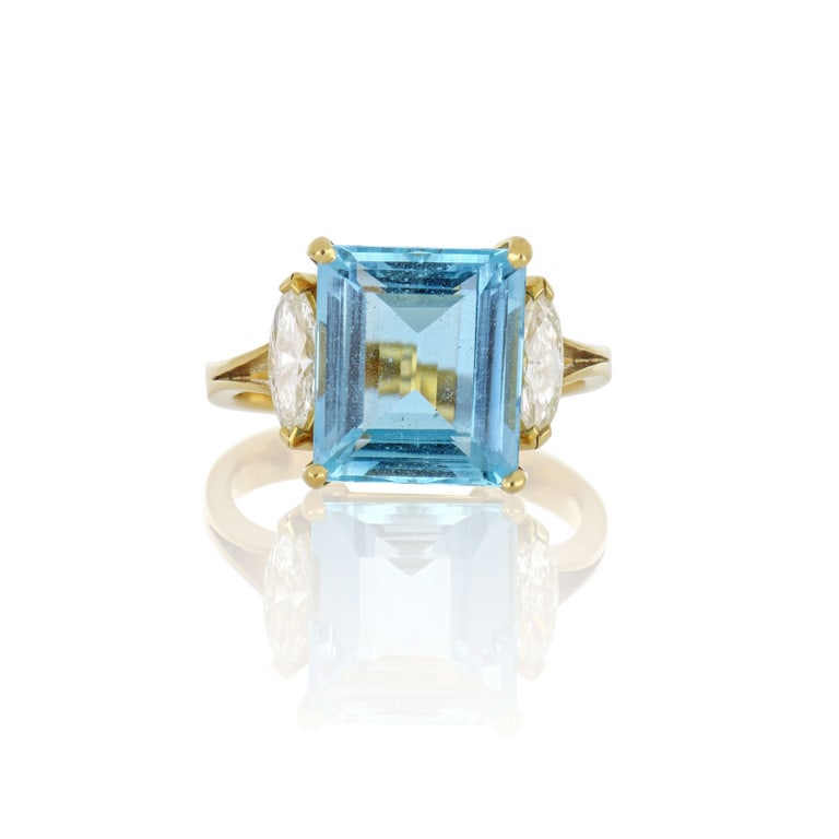 Anello in oro giallo, una luminosa acquamarina: Anello in oro giallo, una luminosa acquamarina taglio rettangolare di ct. 6,00 ca. è affiancata da due diamanti taglio navette di ct. 0,60 ca. complessive. Misura n. 12, riduzioni. Peso 6,25 g.