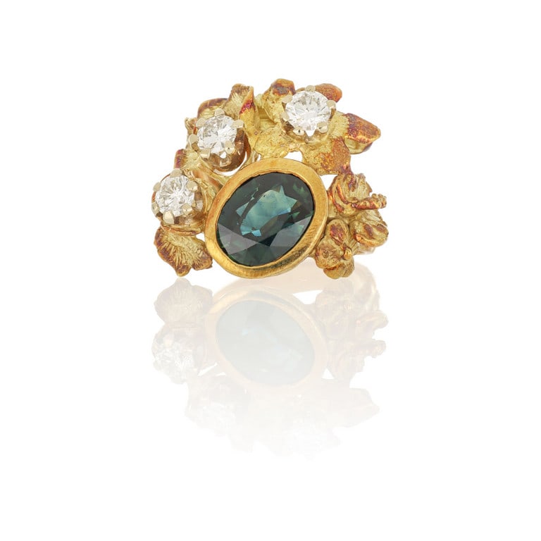 Anello in oro giallo con lavorazione "Sforza", il: Anello in oro giallo con lavorazione "Sforza", il motivo floreale è qui impreziosito da uno zaffiro taglio ovale al centro di ct. 2,50 ca. e 3 diamanti taglio brillante per complessivi ct. 1,20 c