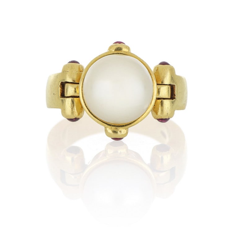 Anello in oro giallo con perla tonda a 3/4: Anello in oro giallo con perla tonda a 3/4 coltivata, piccoli rubini cabochon. Misura 14. Peso 15,36 g.