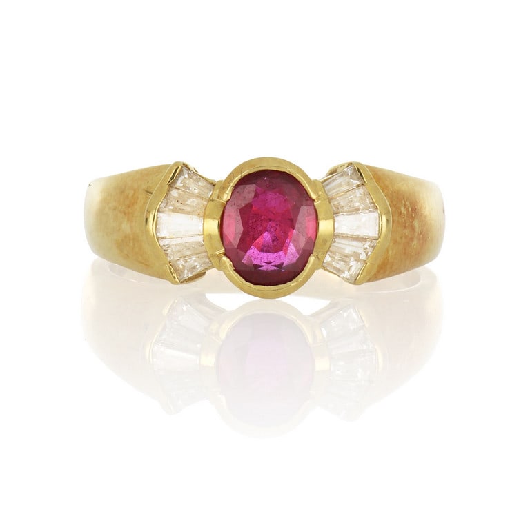 Anello in oro giallo con rubino centrale ovale di: Anello in oro giallo con rubino centrale ovale di circa 1 ct. e ventaglio laterale di baguette di diamanti. Misura 16. Peso 7,53 g.