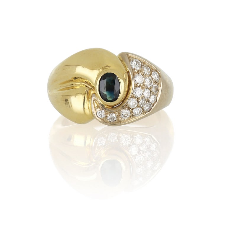 Anello in oro giallo a fascia, realizzato in oro: Anello in oro giallo a fascia, realizzato in oro lucido e con pavè di piccoli diamanti taglio brillante, al centro uno zaffiro taglio ovale. Misura n. 11. Peso 9,48 g.