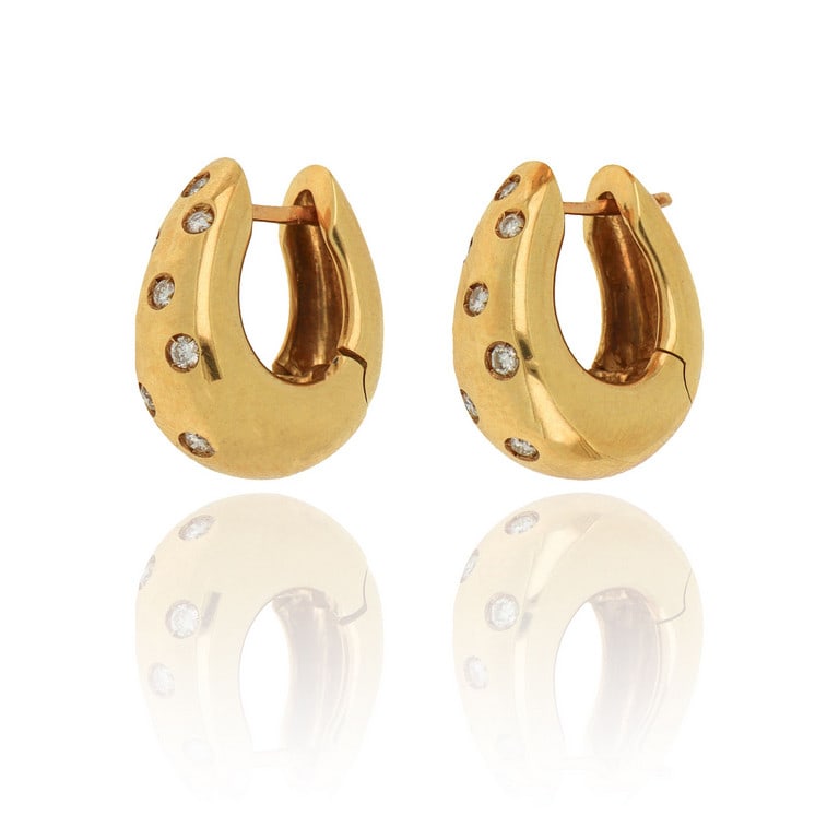 Orecchini a spicchi, realizzati in oro giallo,: Orecchini a spicchi, realizzati in oro giallo, bombati, lucidi e rifiniti con una spruzzata di piccoli diamanti sulla parte a vista, la chiusura a monachella completa questo sportivo modello. Dimensio