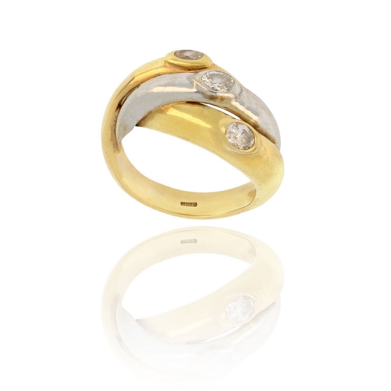 Anello a 3 fedi bombate incatenate, in oro giallo: Anello a 3 fedi bombate incatenate, in oro giallo e bianco, ciascuna decorata con un diamante taglio ovale al centro, ct. 0,45 ca. Misura n. 9. Peso 9,91 g.