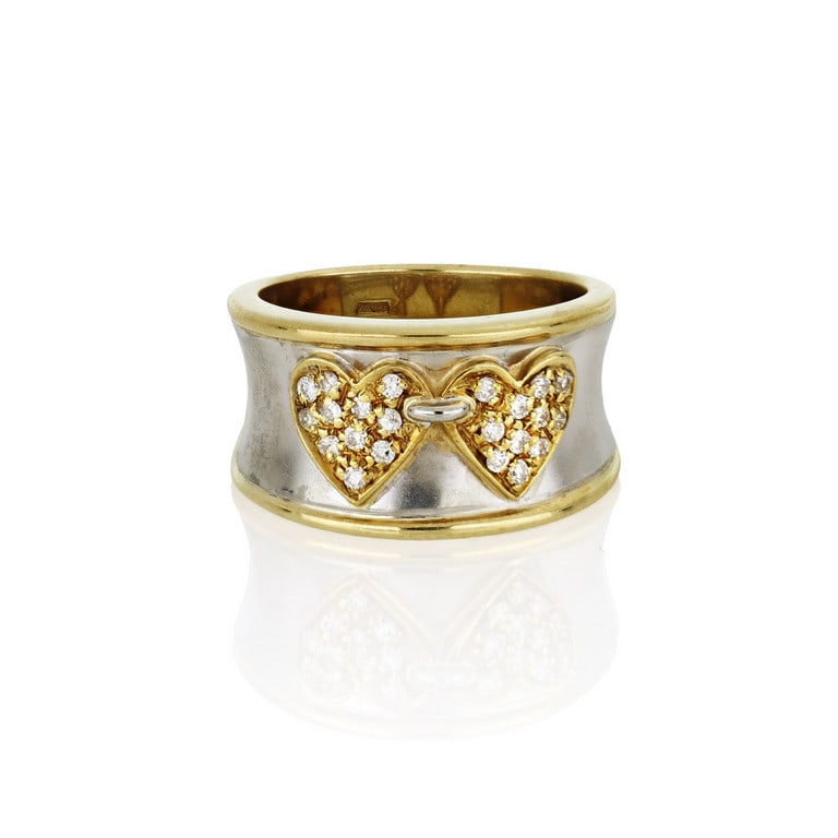 MAGI - Anello a fascia in oro bianco e giallo, al: MAGI - Anello a fascia in oro bianco e giallo, al centro due cuori incatenati, decorati con piccoli diamanti taglio brillante. Misura n. 18. Peso 13,16 g.