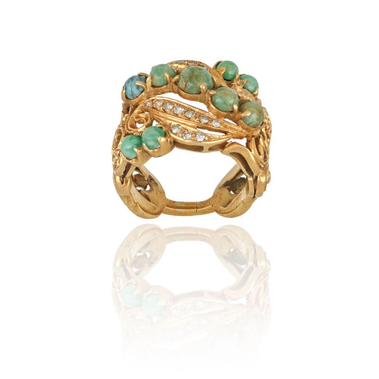 Anello in oro giallo decorativo a volute con: Anello in oro giallo decorativo a volute con piccoli turchesi cabochon. Misura 17. Peso 14,97 g.