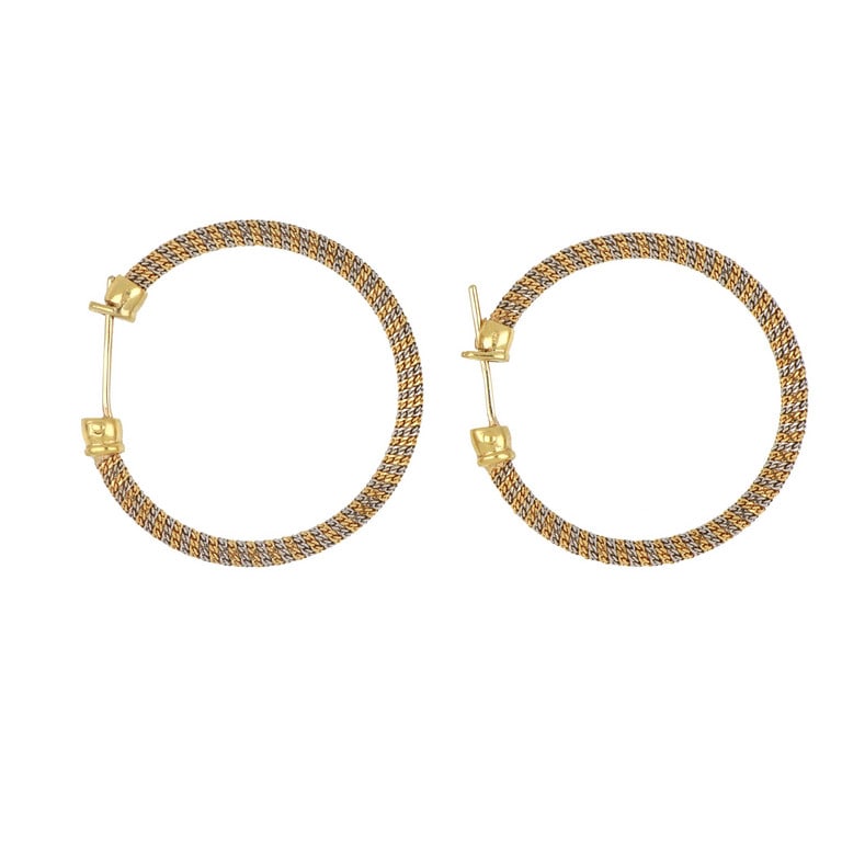 Luminosi orecchini a cerchio, realizzati in oro: Luminosi orecchini a cerchio, realizzati in oro giallo e bianco con lavorazione diamantata, chiusura a monachella. Diametro 4 cm. Peso 13,0 g.